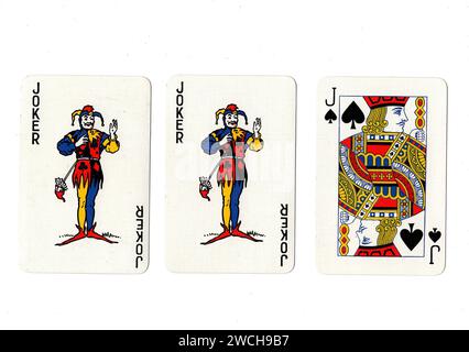 Vintage playing cards showing a pair of jokers and a black jack isolated on a white background. Stock Photo