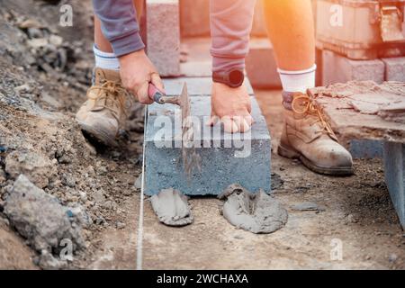 Bricklayer laying high-density footing concrete blocks Stock Photo