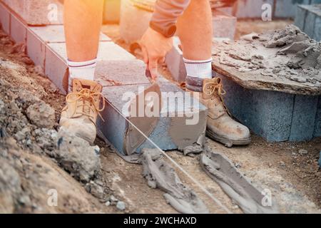 Bricklayer laying high-density footing concrete blocks Stock Photo