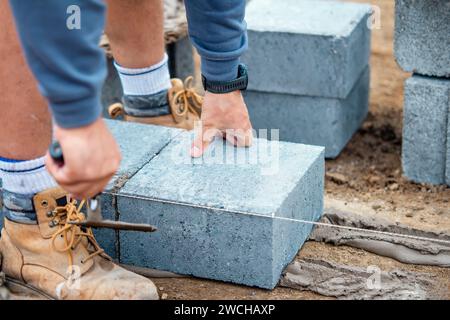 Bricklayer laying high-density footing concrete blocks Stock Photo