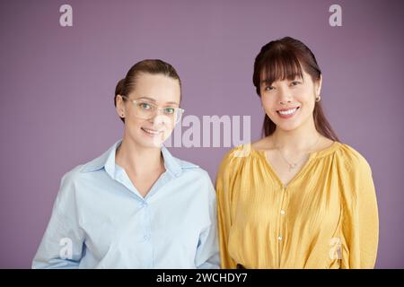 Studio portrait of female coworkers smiling at camera Stock Photo