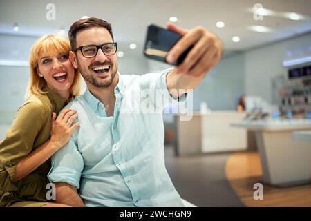 Couple is making selfie using a smart phone. Digital device, artificial intelligence concept. Stock Photo