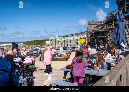 Holidaymakers relaxing socialising on the outdoor decking area of the Fistral Beach Bar in Newquay in Cornwall in England in the UK. Stock Photo