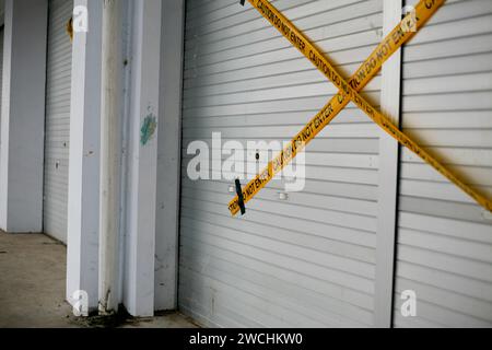 The caution police line do not enter on the metal rolling door Stock Photo