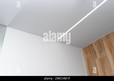 LED light strips mounted in the wall and ceiling in a modern bathroom. Stock Photo