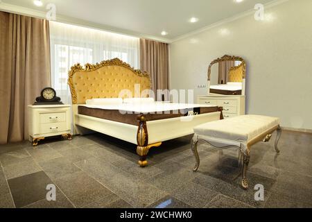 golden furniture details. Big comfortable double royal bed in white background Stock Photo