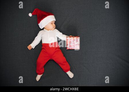 sleeping boy in Santa's hat is lying with a gift box in his hand and a copy of space Stock Photo