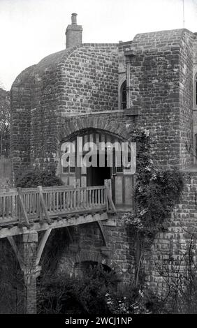 1960s historical, rear entrance of Walmer Castle, Walmer, Deal, Kent, England, UK showing wooden bridge over the moad. This is also the entrance from the gardens.  Completed circa 1540, the Tudor fortress was orginally constructed by Henry VIII to protect the English coast against a possible invasion by the French. The building later became a country house and the official residence of the Lord Warden of the Cinque Ports. Some of the most famous people in England having lived there or used it, including the Duke of Wellington, W. H Smith and Winston Churchill. Stock Photo