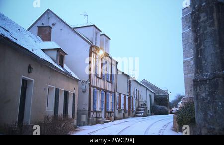 A charming, picturesque country road winding through historic houses and towering buildings in Saint-Loup-de-Naud Stock Photo