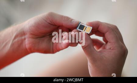 a guy is holding a sim card in his hand together with a memory card and ready to insert into the phone. Stock Photo
