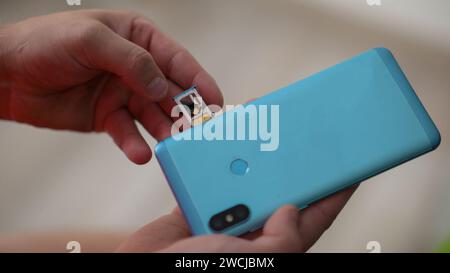 inserting a sim card into the phone, close-up view. Stock Photo