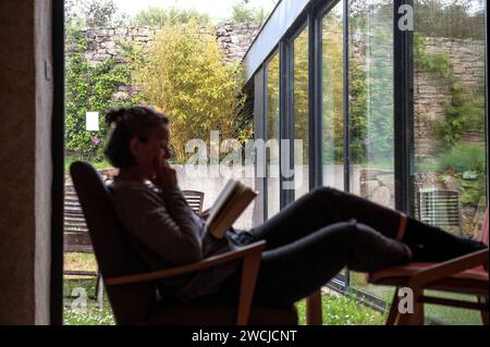 Woman reading a book in modern house Stock Photo