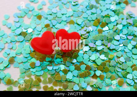 Two red hearts on background of small bright green hearts Stock Photo