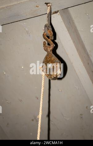 Old Rope Hanging from Rusty Pulley Stock Photo