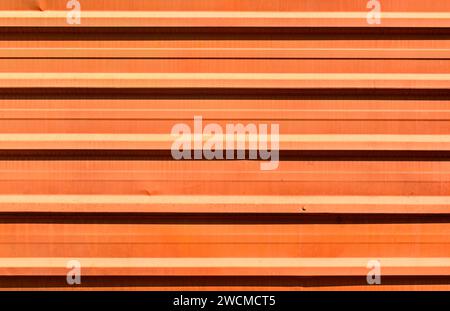 Orange corrugated metal plate surrounding wasteland Stock Photo