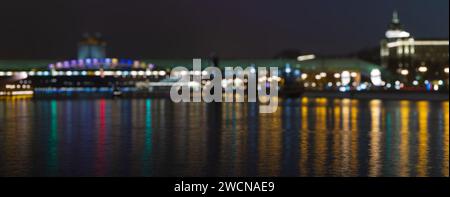Night view with bokeh on the city lights. Abstract background of city at night. Reflection of lights in the river. Blurred bokeh city lights backgroun Stock Photo