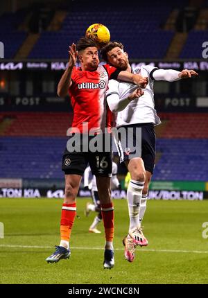 Luton Town's Reece Burke (left) and Bolton Wanderers' Jack Iredale battle for the ball during the Emirates FA Cup third round replay match at the Toughsheet Community Stadium, Bolton. Picture date: Tuesday January 16, 2024. Stock Photo