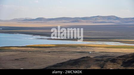 Mountain landscape with Lake Song Kul, view of yurts and horses on the lakeshore, Naryn region, Kyrgyzstan Stock Photo