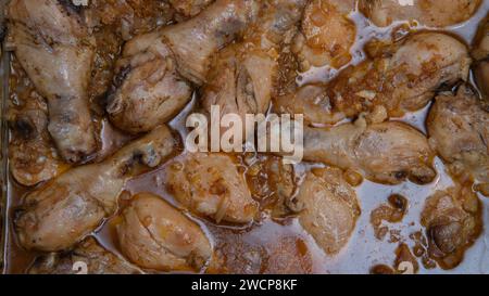 Overhead view of skinless chicken legs baked in sauce with vegetables Stock Photo