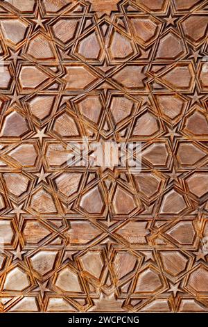 Islamic style geometric carving detail with intricate star shapes from a door of a mosque, traditional handcrafted oriental architectural fragment bac Stock Photo