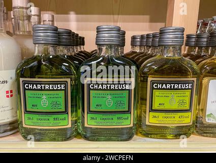 Small flask shaped bottles of Chartreuse liqueur for sale. Stock Photo