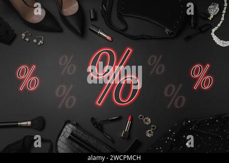 Discount offer. Women's clothes, makeup products, accessories and percent signs on black background, flat lay Stock Photo
