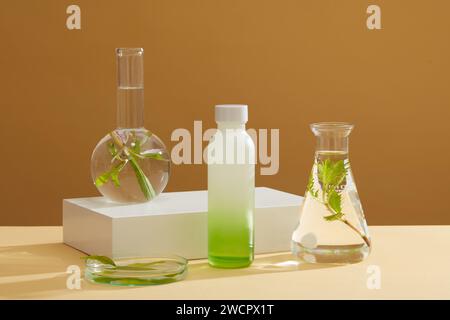 Unbranded bottle in gradient green color displayed several glassware filled with water and seaweed. Seaweed is ideal for dry and aging skin types Stock Photo