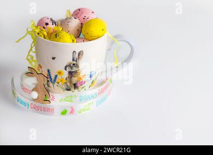 Easter eggs in a Easter theme cup on white background, copy space, Easter concept Stock Photo