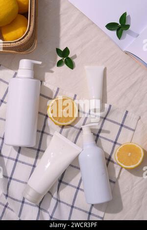 Several types of cosmetic container decorated on a checkered fabric with a basket of lemons. Empty label for cosmetic product mockup of Lemon (Citrus Stock Photo