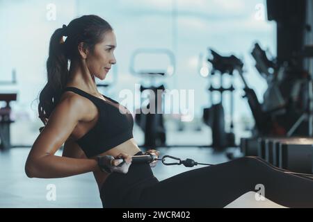 Sporty woman exercising on multistation at gym for arm and shoulders muscles. Fitness exercising in gym. Stock Photo