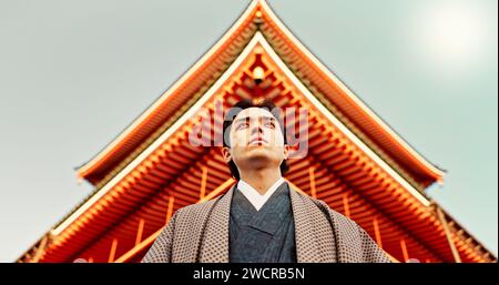 Asian, man at temple in Japan and religion, low angle view for mindfulness, culture and tradition. Worship, peace and walking in traditional clothes Stock Photo