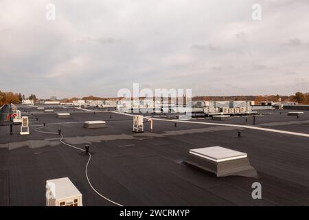 Drone photography of large commercial building rooftop with air conditioning machinery during autumn sunny morning Stock Photo