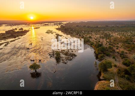 The sunrise can be seen over the Zambezi River in Zimbabwe's Zambezi National Park, Victoria Falls. Stock Photo