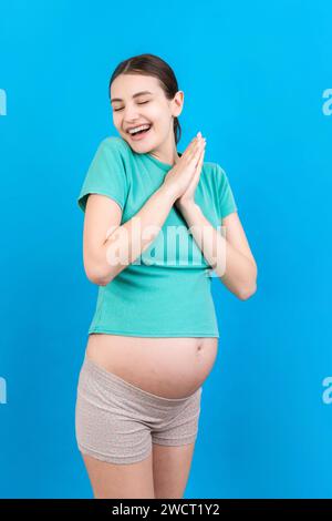 Young beautiful pregnant woman on isolated colored background celebrating surprised and amazed for success with arms raised and open eyes. Winner conc Stock Photo