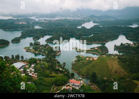 Aerial view of a serene lake with a small island, a fountain, and dense ...
