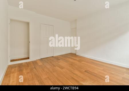 Closed white doors and hardwood floor in unfurnished bedroom at modern apartment with walls and doorway Stock Photo