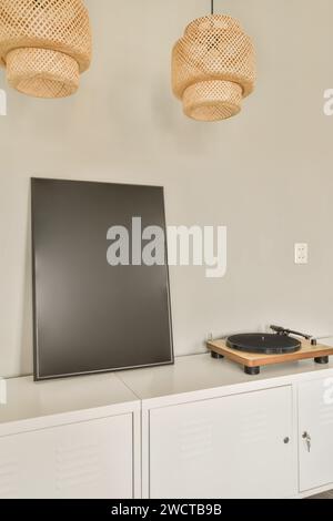 Blank painting canvas and turntable on white wooden cabinet in contemporary apartment with pendant lights Stock Photo
