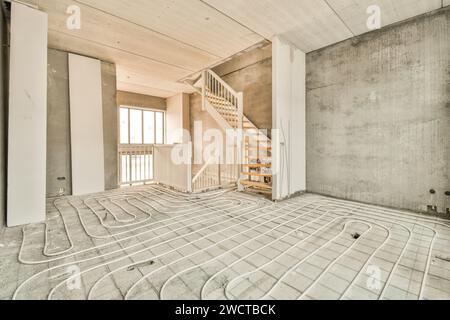 the inside of a house under construction with pipes running through the floor and stairs leading up to the second floor Stock Photo