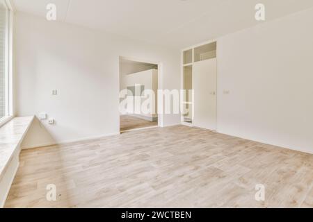 A spacious room features a wooden floor, white walls, and a minimalist design, ideal for a modern living space. Stock Photo