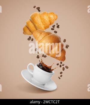 Fresh croissants, aromatic coffee and roasted beans in air on dark beige background Stock Photo