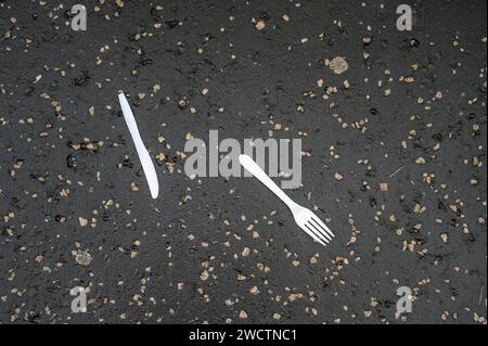 Plastic knife and fork discarded on a pavement Stock Photo