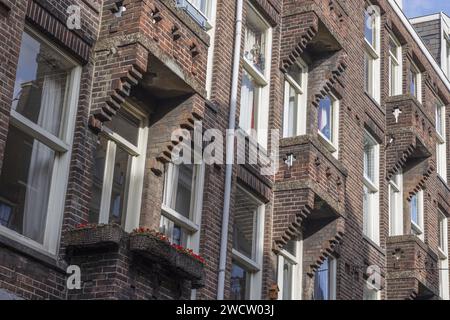 Picture of symetric house facade made of clinker bricks with balconies during daytime Stock Photo