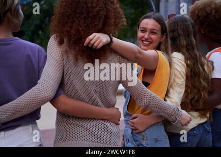 Group of happy young multiracial people embracing together outdoors. Stock Photo