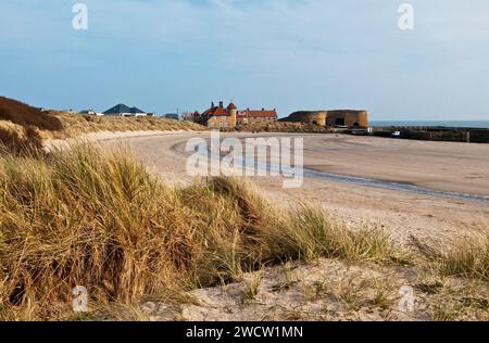 Beadnell Harbour and Beach Northumberland Coast in March showing the limekilns, houses and harbour wall on a sunny day Stock Photo
