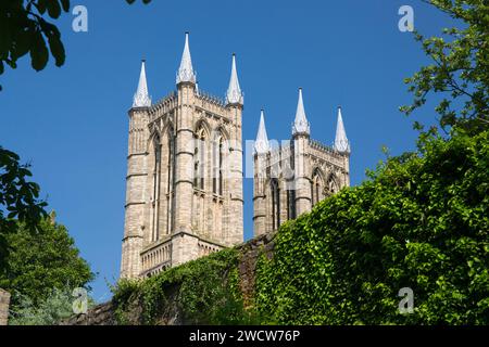 Lincoln, Lincolnshire, England. Low angle view from gardens of the Bishop's Palace to the twin west towers of Lincoln Cathedral. Stock Photo