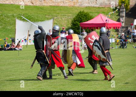 Lincoln, Lincolnshire, England. Costumed warriors taking part in a medieval battle re-enactment on the lawns of Lincoln Castle. Stock Photo