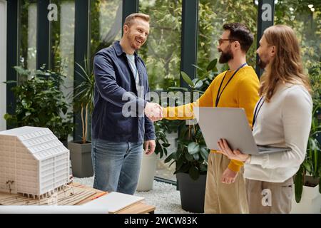 merry attractive architects in casual outfits working together on their startup, coworking concept Stock Photo