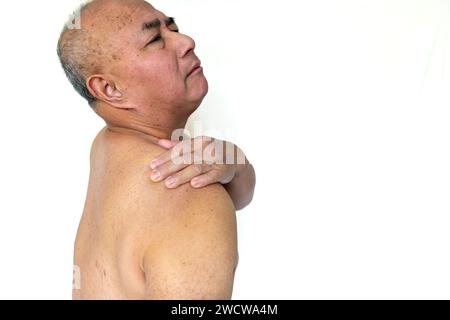 A senior man suffering from pain in the shoulder isolated in a white background Stock Photo