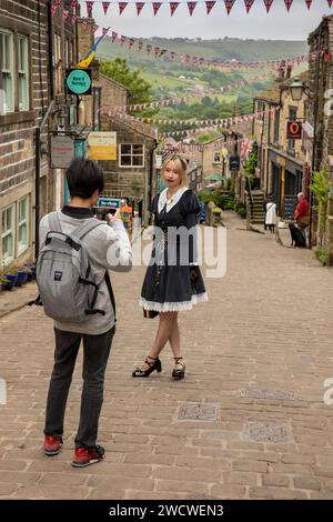 UK, England, Yorkshire, Worth Valley, Haworth, Main Street, Korean visitors taking souvenir photograph Stock Photo