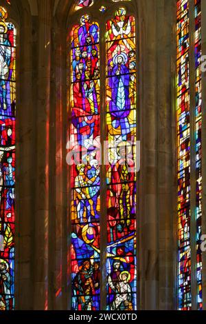 France, Vosges, Charmes, St Nicolas church built in 1493 in Renaisssance style, stained glass window of the choir made in 1962-1963 by masters glassmakers from Barillet workshop in Paris after the drawings by jacques Hallez representing on the bottom Jesus and the teachers in the Temple, in the middle Jesus chained brought by the Roman soldiers before Pilatus, on top the Holly Spirit, Jesus with a dove above his head Stock Photo